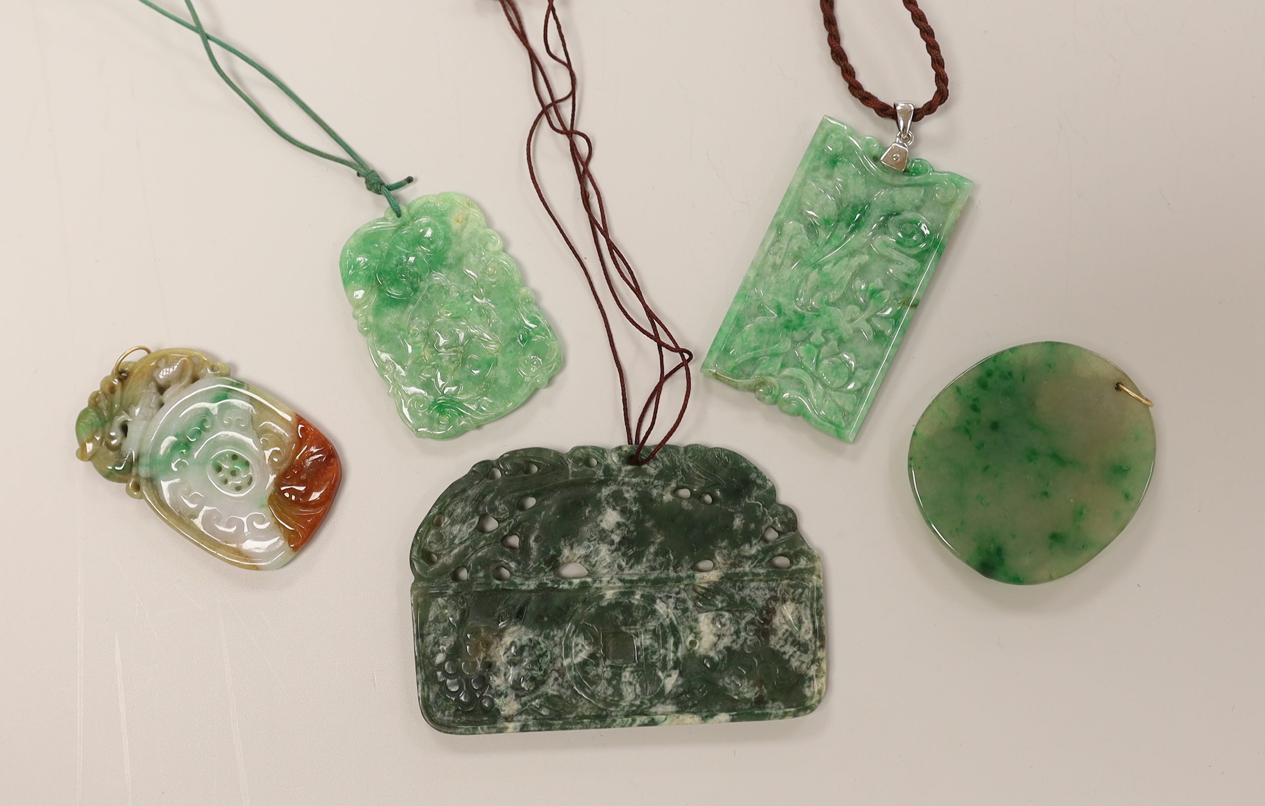 Five assorted jadeite pendants, largest 8cm wide